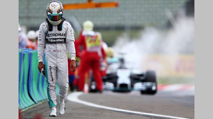 Ο απογοητευμένος Lewis Hamilton περπατάει προς τα pits αφού το μονοθέσιό του έπιασε φωτιά νωρίς στα προκριματικά, γεγονός που τον αναγκάζει να εκκινήσ