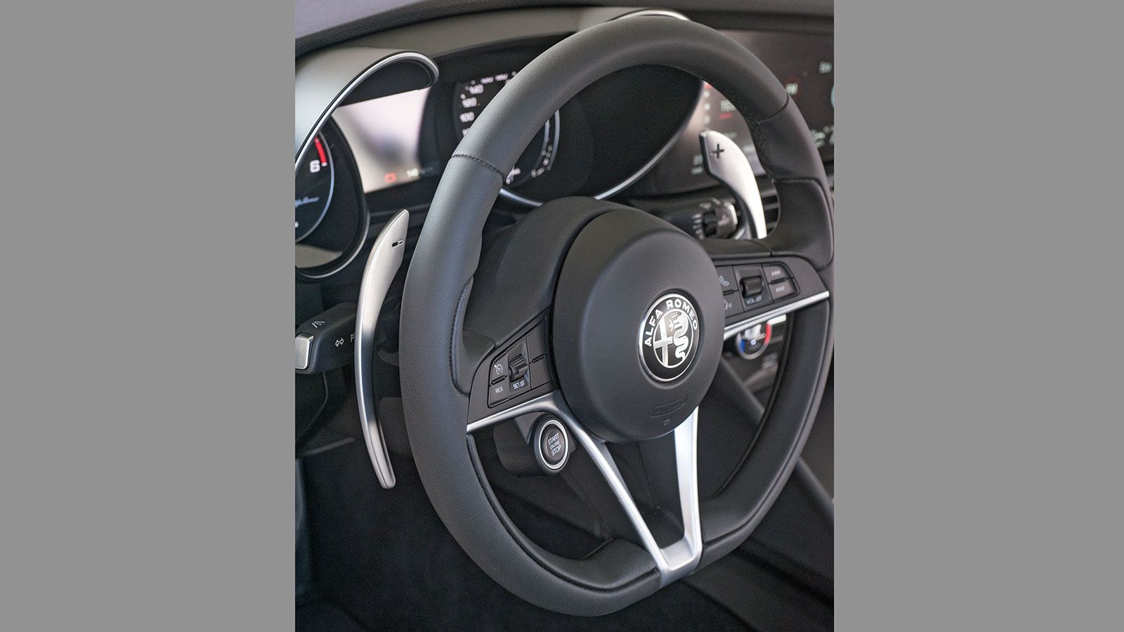 Πίνακας οργάνων με κάθετες βελόνες, μεγάλα paddles και ιδιαίτερο τιμόνι με το κουμπί start του κινητήρα ενσωματωμένο. Μια εικόνα τόσο επικεντρωμένη στ