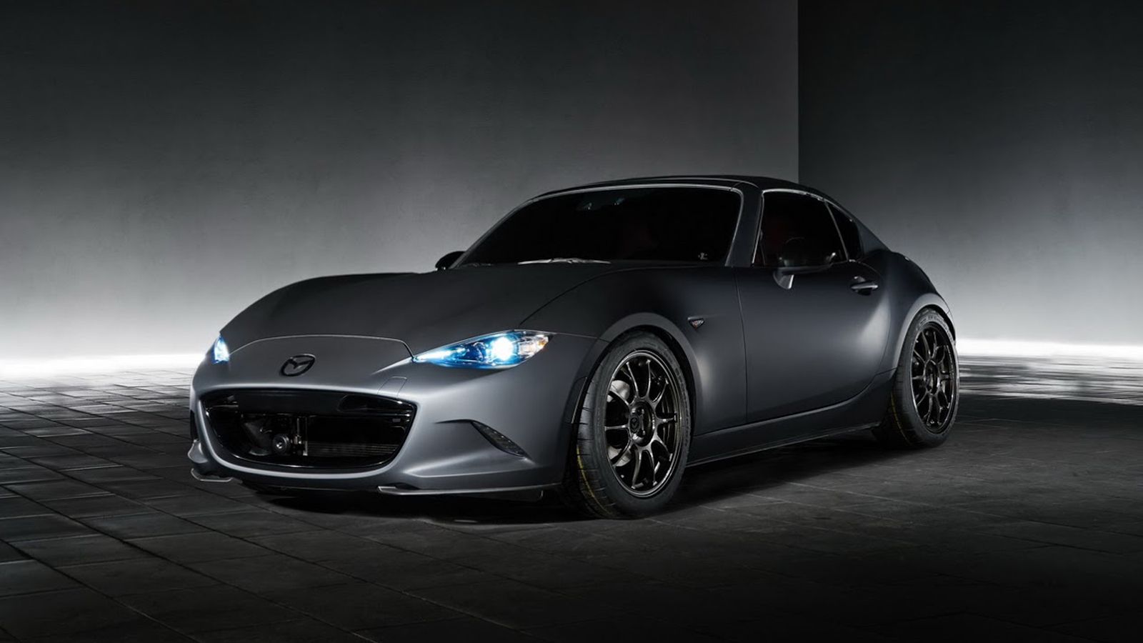 Το σκούρο γκρι MX-5 RF Kuro φορά ζάντες 17 ιντσών, ενώ έχει δανειστεί από το αγωνιστικό MX-5 Cup τη ρυθμιζόμενη ανάρτηση. Ξεχωρίζουν η κεντρική απόληξ