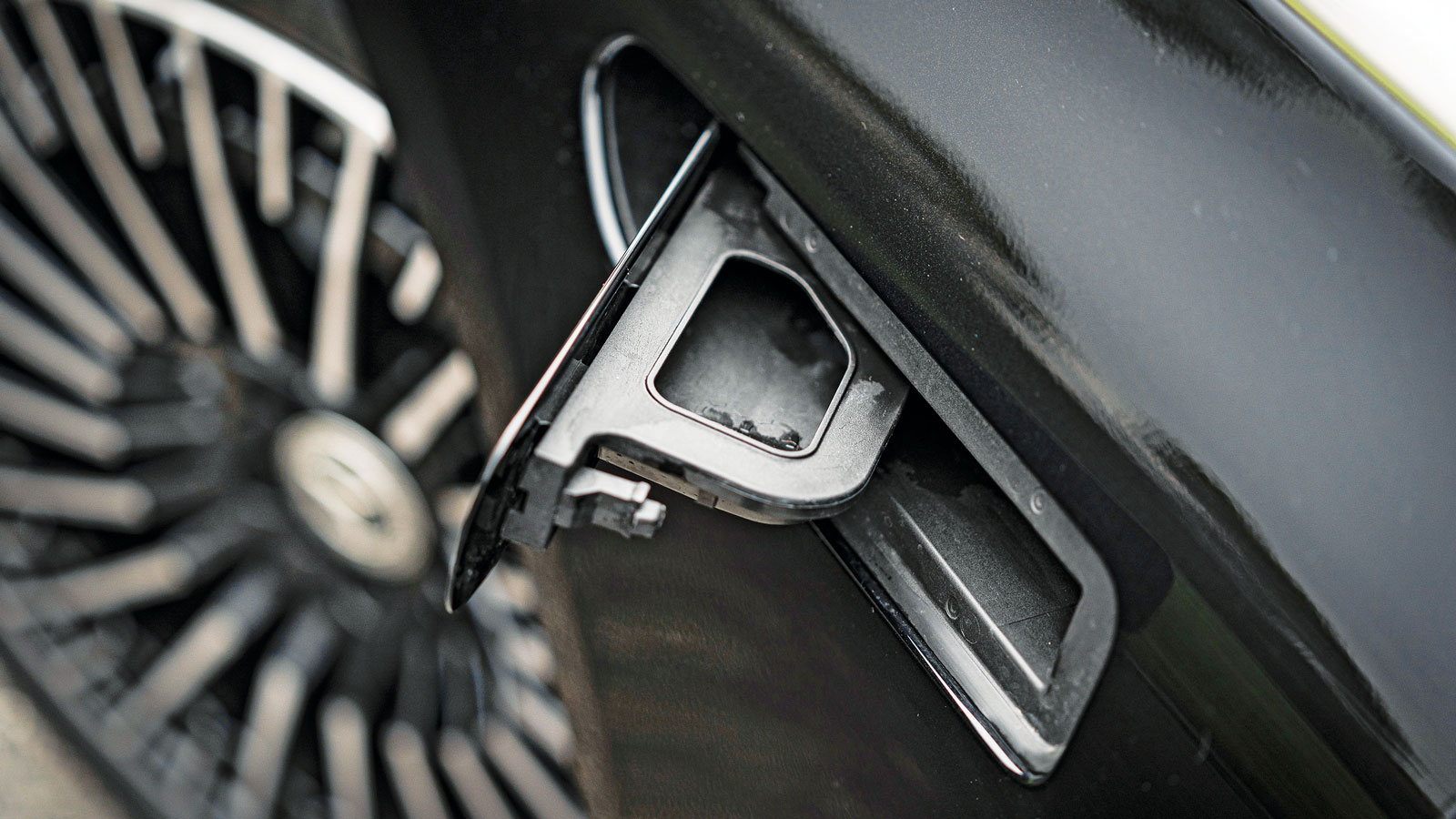 Οι χειρολαβές κρύβονται μέσα στο αμάξωμα, προφανώς για μέγιστη αεροδυναμική. Αυτή η τάπα όμως που βρίσκεται από την αριστερή μεριά κάτω από την μπροστ