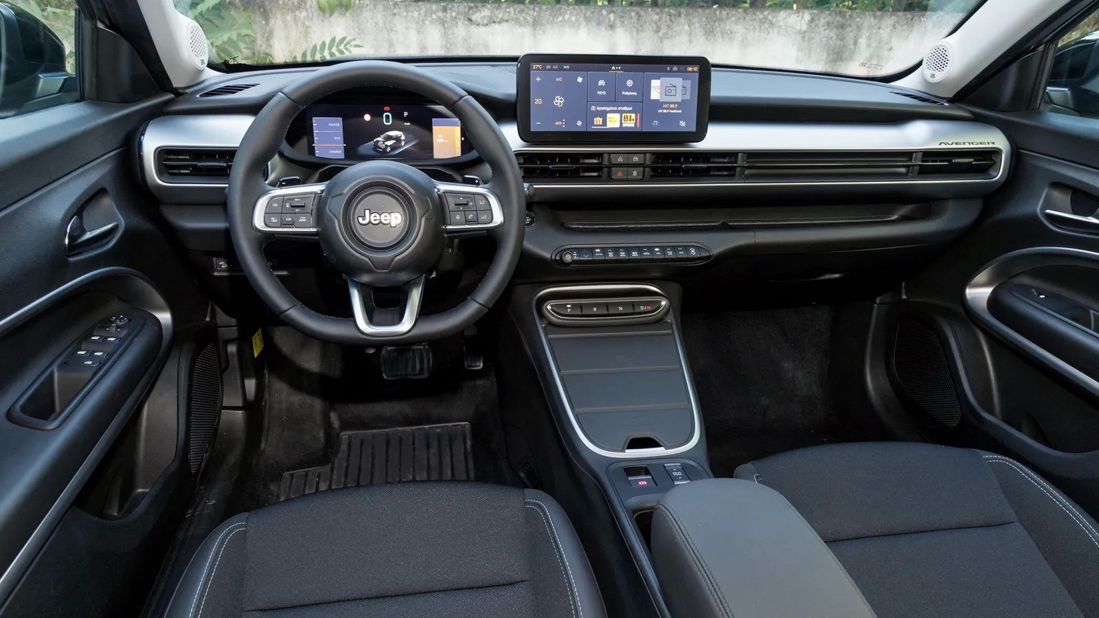 Υλοποιημένο αποκλειστικά από σκληρό πλαστικό, αλλά στιβαρό, καλοφινιρισμένο και μοντέρνο το ταμπλό του Jeep Avenger e-Hybrid, με στάνταρ κεντρική οθόν