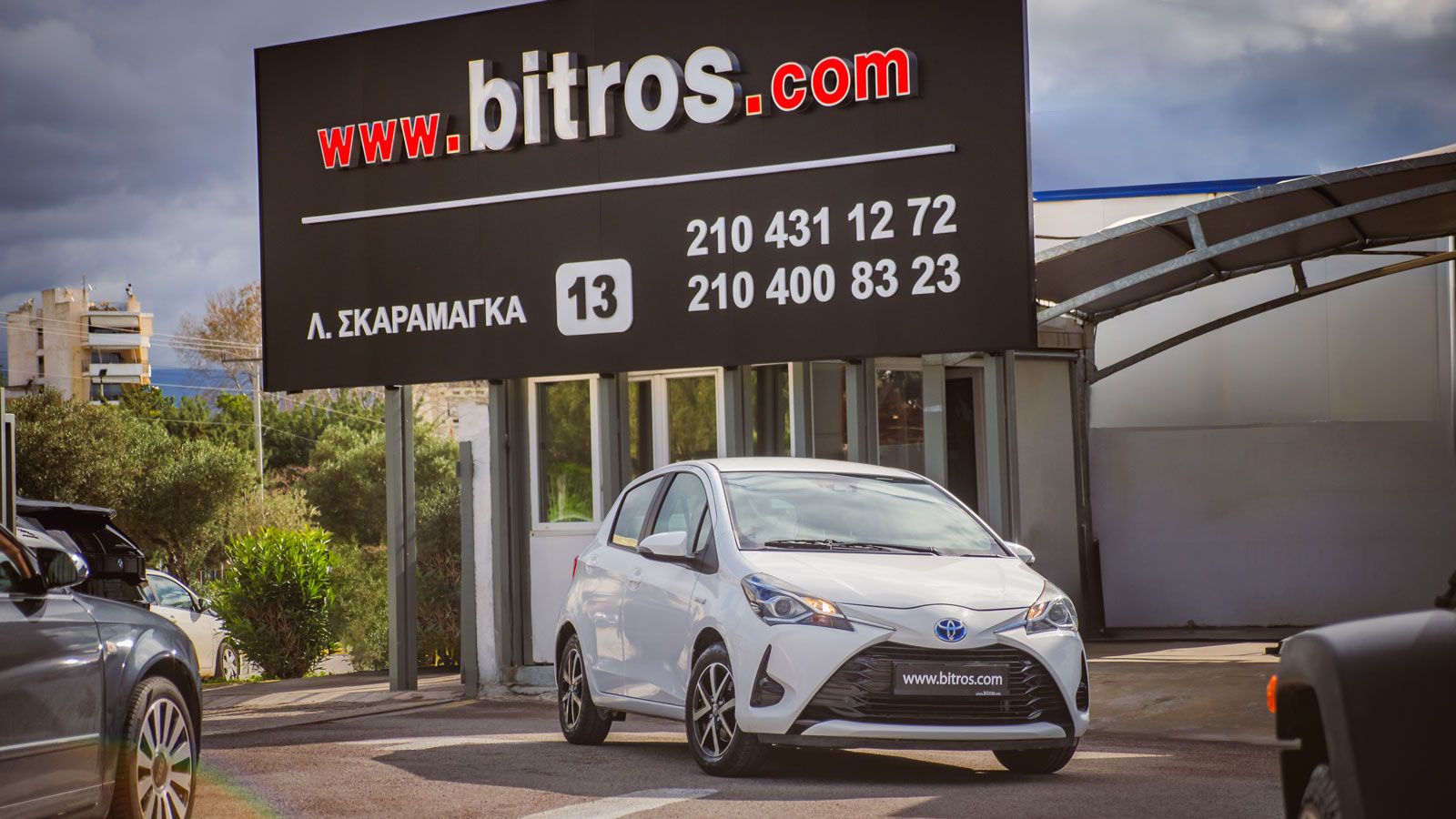 Το Toyota Yaris HSD εμπρός από την εμπορία Μπίτρος