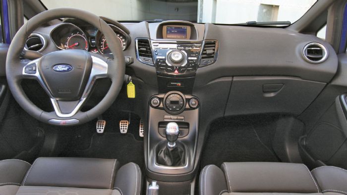 Διακριτικά σπορτίφ το εσωτερικό του Ford Fiesta ST, με λογότυπα «ST» και αλουμίνιο στις επενδύσεις.