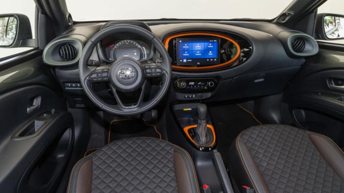 Μοντέρνα είναι η σχεδίαση στο εσωτερικό του Toyota Aygo X, όπως αυτή εκφράζεται με τον κυκλικό πίνακα οργάνων πίσω από το 3-άκτινο δερμάτινο τιμόνι και την άριστα ενσωματωμένη, στην ελλειψοειδή διαμόρφωση του ταμπλό, οθόνη αφής. Μοντέρνα είναι η σχεδίαση στο εσωτερικό του Toyota Aygo X, όπως αυτή εκφράζεται με τον κυκλικό πίνακα οργάνων πίσω από το 3-άκτινο δερμάτινο τιμόνι και την άριστα ενσωματωμένη, στην ελλειψοειδή διαμόρφωση του ταμπλό, οθόνη αφής.