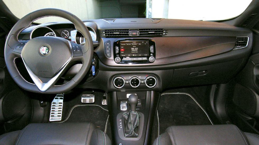Στο εσωτερικό της Giulietta QV, ξεχωρίζουν το σπορ τιμόνι και η αλουμινένια πεταλιέρα. Όμορφη και η α λα μέταλλο οριζόντια επένδυση στο ταμπλό.