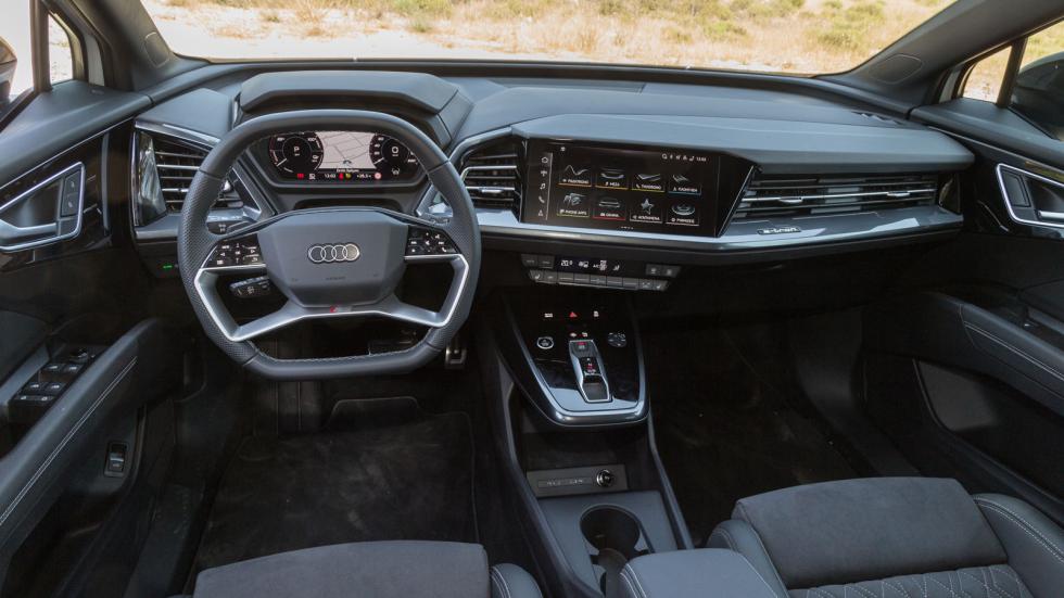 Στοιχεία που τραβούν την προσοχή στο Audi Q4 e-tron είναι o ψηφιακός και διαμορφώσιμος πίνακας οργάνων, ο οποίος εδράζεται πίσω από το ρετρομοντέρνο τετράκτινο τιμόνι, ο μικρός by wire επιλογέας του κ